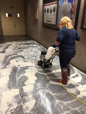 Staffperson refinishing floor